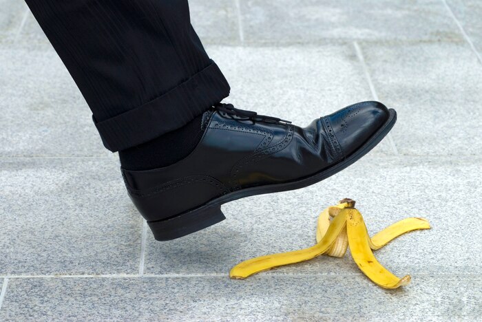 A person is going to step on a banana peel