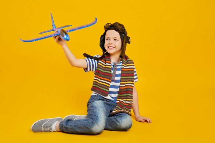 Smiling boy playing with toy plane