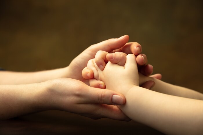 Holding hands, clapping like friends. close up shot of female and kid\'s hands doing different things together. family, home, education, childhood, charity concept. mother and son or daughter, wealth.