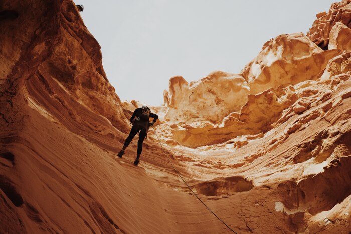 Man trying to climb the cliffs of the canyon