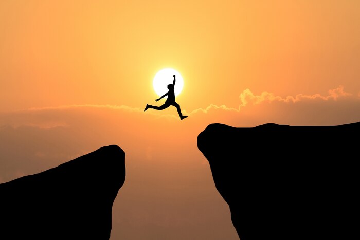 Courage man jump through the gap between hill ,business concept idea