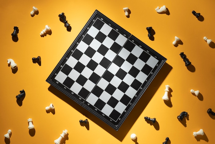 Chess pieces and chess board on yellow background