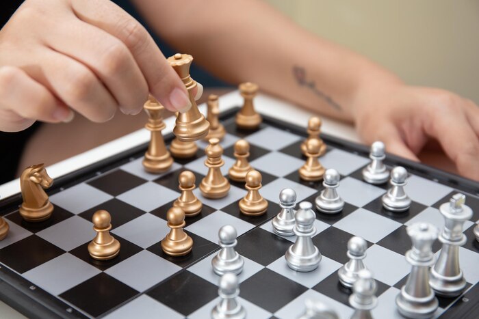 Female hand moving chess piece on the chessboard