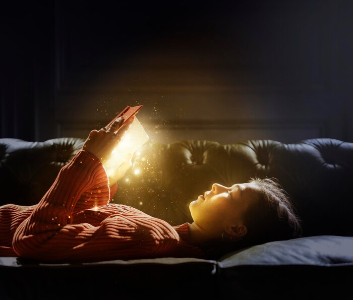 Girl reading from a magical glowing book
