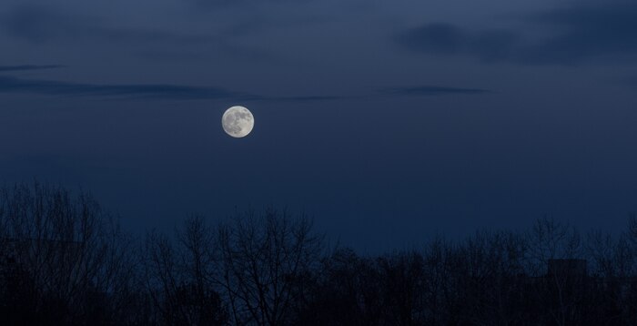 Full moon in the dark sky during moonrise