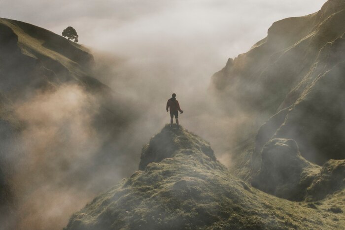 Man standing on cliff with fog overlay texture