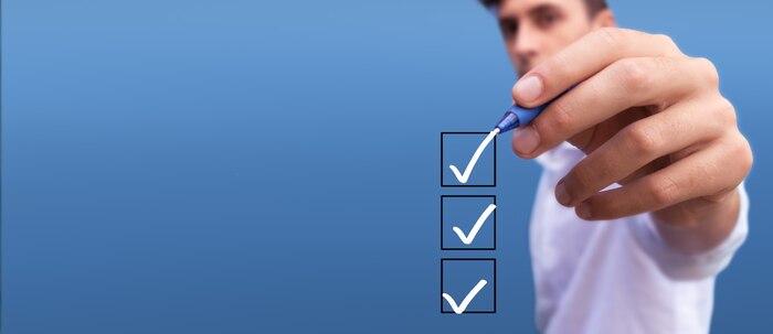Young man checking boxes with list of 3 options on blue background check list marks signs