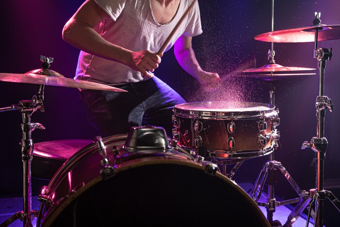 The drummer plays the drums.