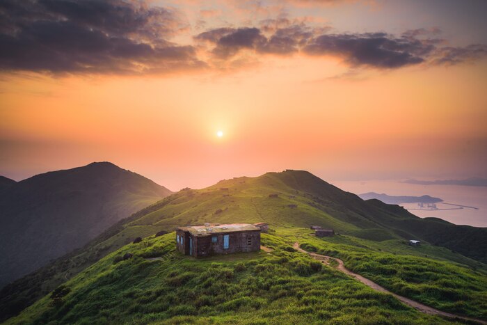 Small house built on a peaceful green hill high up in the mountains
