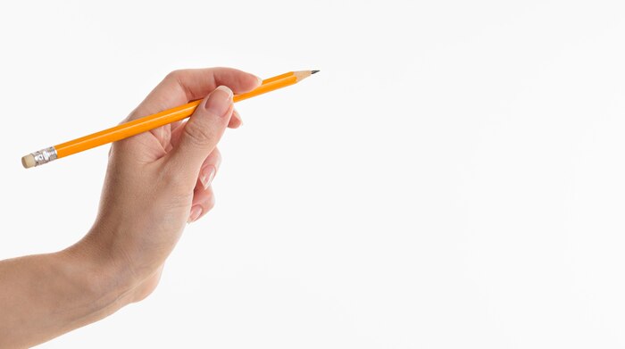 Hand holding pencil with copy space