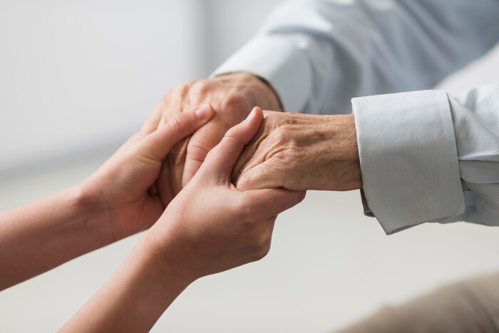 Nurse holding senior man\'s hands for sympathy